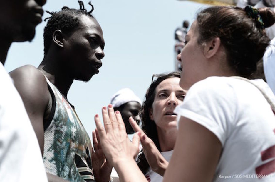 Una integrante de MSF habla con uno de los migrantes en el ‘Aquarius’. (AFP)