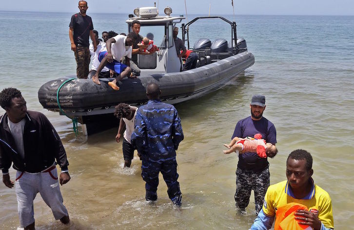 Las fuerzas de seguridad libias, con los cadáveres de los bebés fallecidos en el naufragio. (Mahmud TURKIA/AFP)