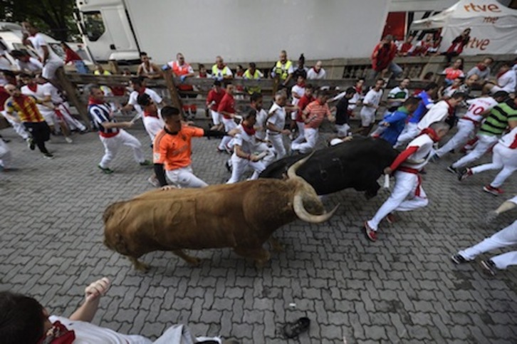 El toro Hechizo está a punto de empitonar a un corredor en el tramo del callejón. (Gorka RUBIO/FOKU)