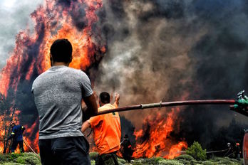 Bomberos y voluntarios trabajan para extinguir las llamas. (Angelos TZORTZINIS/AFP) 