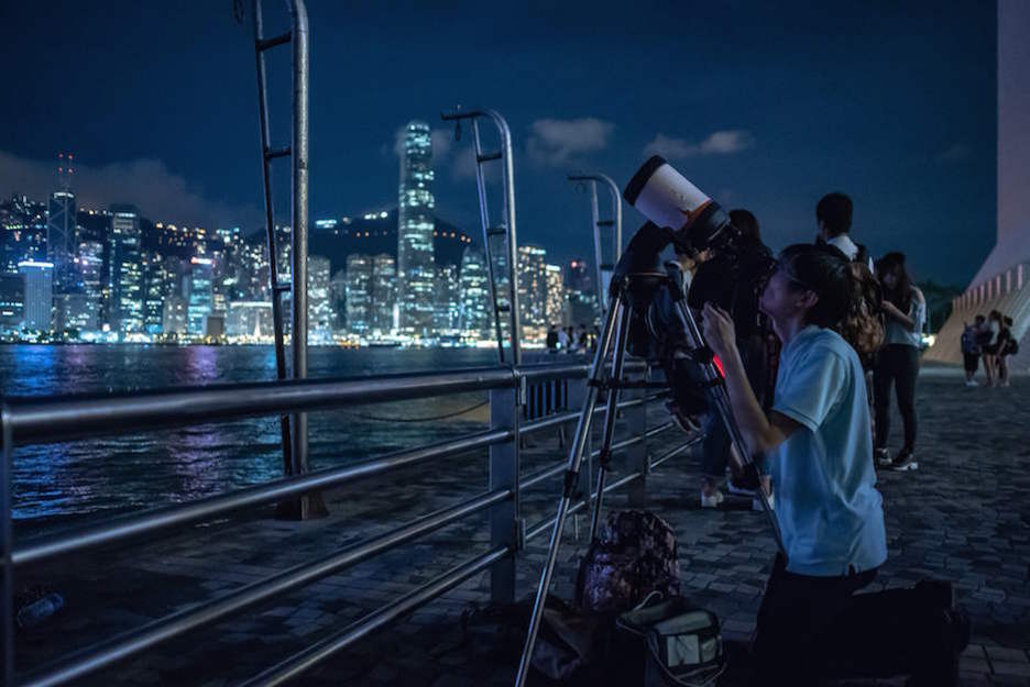 Una persona mira por su telescopio en Hong Kong. (Philip FONG / AFP)