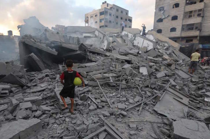 Un niño palestino observa las ruinas de un edificio derribado por un bombardeo israelí sobre la Franja de Gaza. (Mahmud HAMS/AFP)
