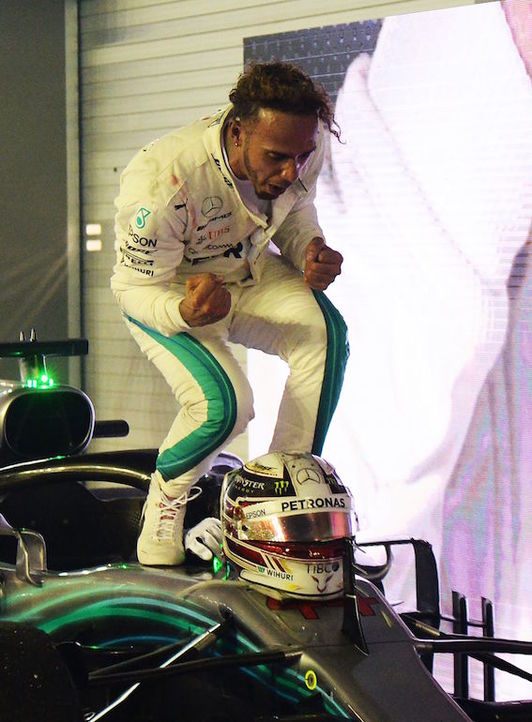 Hamilton celebra la victoria subido a su monoplaza. (Roslan RAHMAN/AFP)