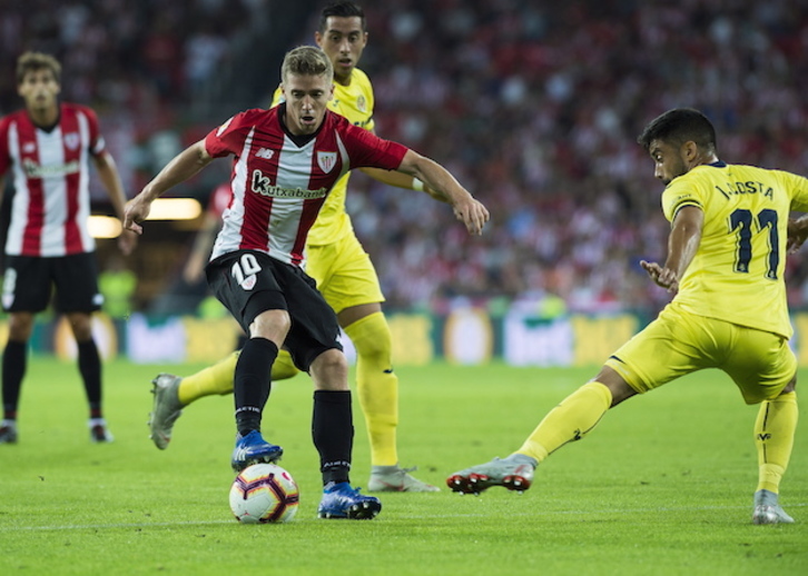 Muniain controla un balón con dos rivales cerca. (Luis JAUREGIALTZO / FOKU)