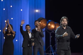 Isaki Lacuesta, con parte del equipo de ‘Entre dos aguas’, tras recoger la Concha de Oro. (Juan Carlos RUIZ/FOKU)