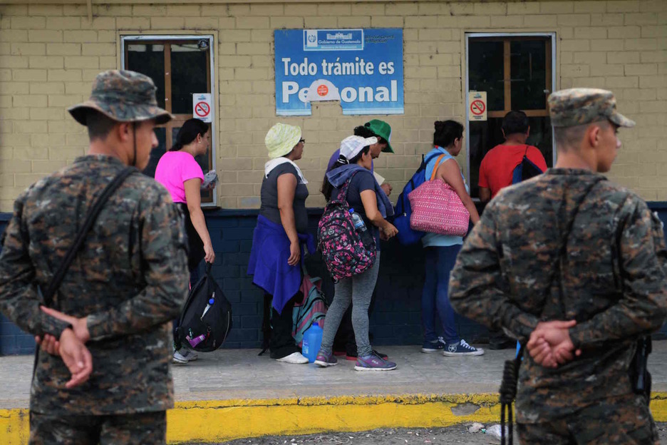 Un grupo de migrantes hace cola en la aduana de Ciudad Pedro de Alvarado, en Guatemala. (Marvin RECINOS/AFP)