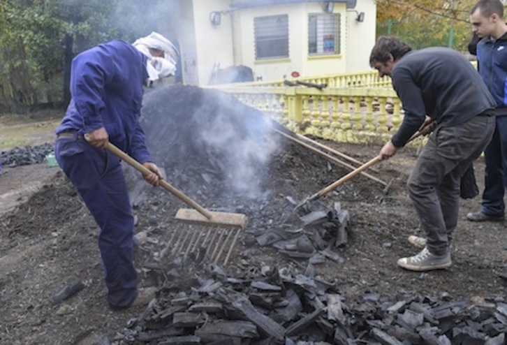 Retirando el carbón vegetal que ha conseguido realizarse con la txondorra de Sanduzelai. (Idoia ZABALETA/FOKU)