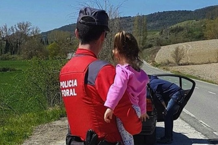 Un agente sostiene a una niña en una intervención por violencia de género. (POLICÍA FORAL)