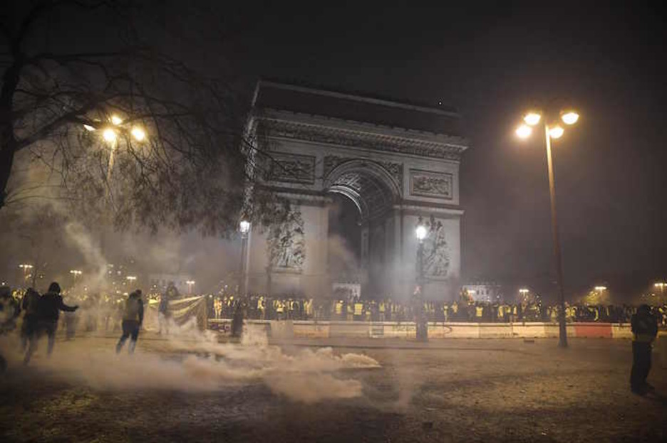 Manifestariak Garaipen Arkuaren inguruan, gas negar-eragilez inguratuta. (Alain JOCARD/AFP) 