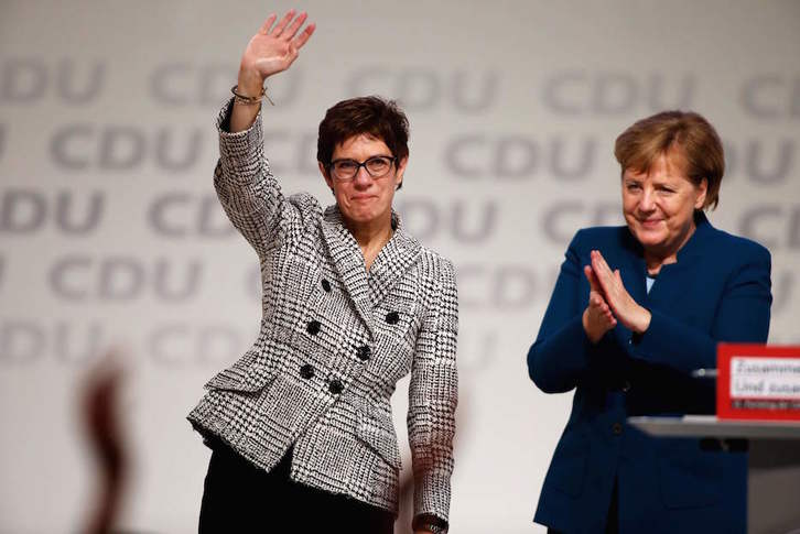 Kramp-Karrenbauer saluda mientras es aplaudida por Angela Merkel. (Odd ANDERSEN / AFP) 