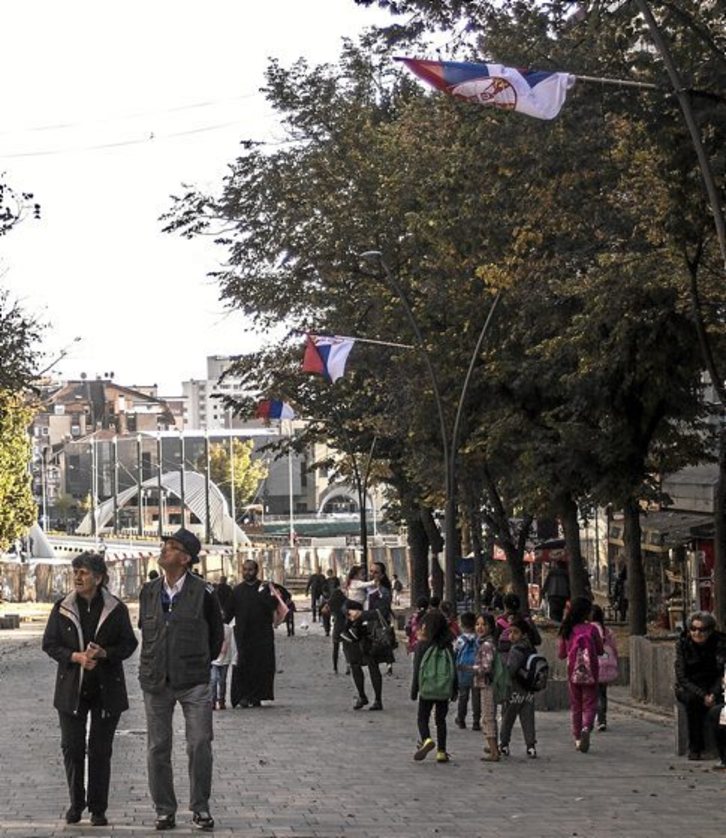 Varias personas caminan por el centro del norte de Mitrovica. (Miguel FERNÁNDEZ IBÁÑEZ)
