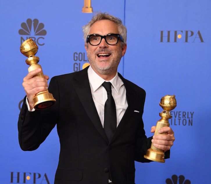 El mexicano Alfonso Cuarón, con los dos galardones que se ha llevado ‘Roma’. (Mark RALSTON/AFP)