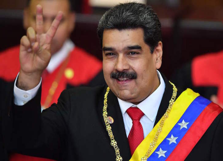 Nicolás Maduro, sonriente, con los atributos presidenciales tras jurar su segundo mandato. (Yuri CORTEZ/AFP)