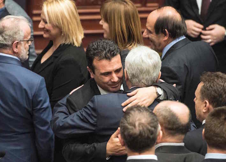 El primer ministro macedonio, Zoran Zaev, saluda a otro parlamentario, tras la votación en la Cámara. (Robert ATANASOVSKI/AFP)