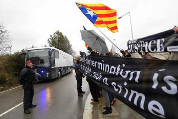 El autobús de la Guardia Civil que traslada a los presos catalanes sale de la cárcel de Brians entre muestras de solidaridad. (Lluís GENÉ/AFP)