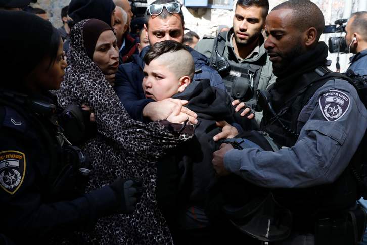 Un niño es detenido en el desalojo de la vivienda de una familia palestina para entregársela a colonos israelíes. / Ahmad GHARABLI (AFP)