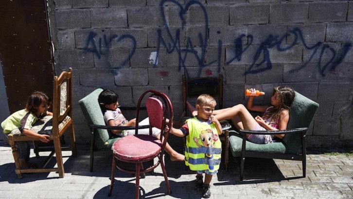 Varias niñas descansan al sol tras jugar en la calle. (AFP)