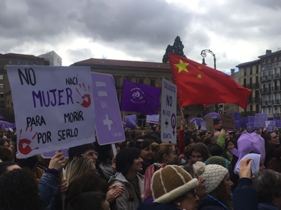 Una bandera de China emerge entre el gentío.