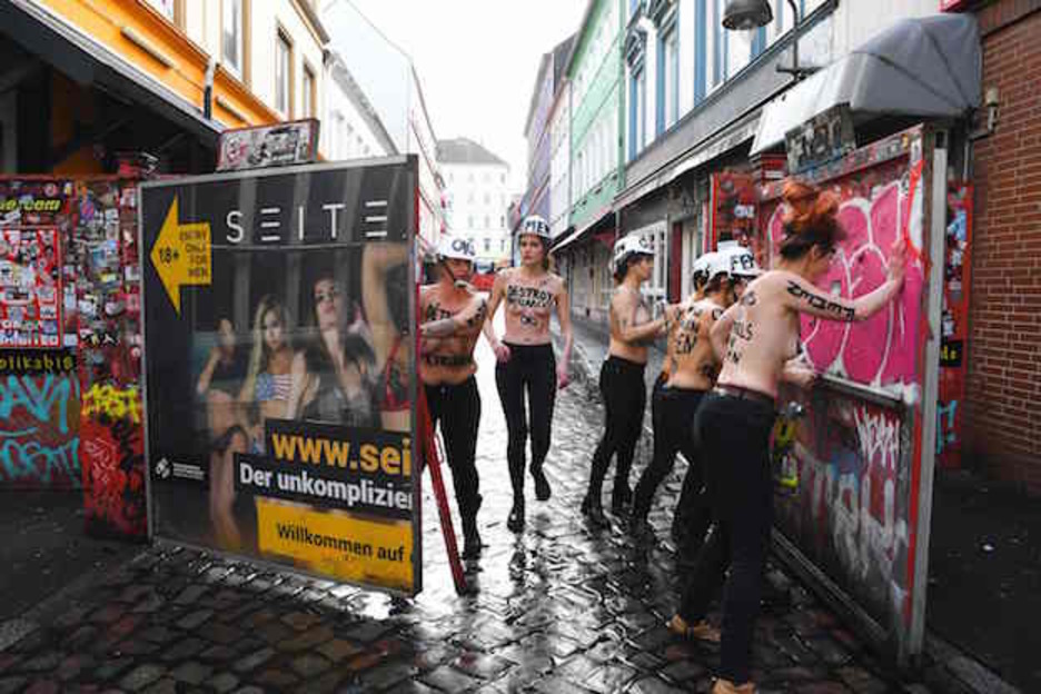 Activistas de Femen desmontan las puertas de acceso a la Herbertstrasse, calle de prostíbulos del barrio rojo de Hamburgo. (PATRIK STOLLARZ / AFP)