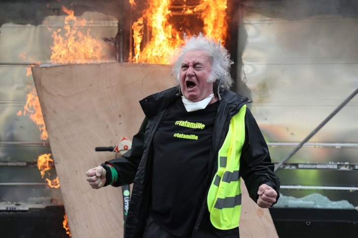 Un «chaleco amarillo» en frente de un quiosco en llamas. (Zakaria ABDELKAFI /AFP)