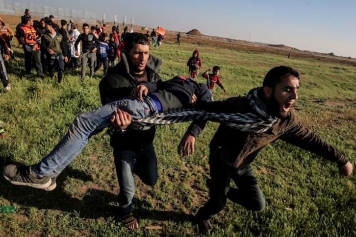 Palestinos trasladan a un herido durante las protestas de ayer. (Said KHATIB / AFP)