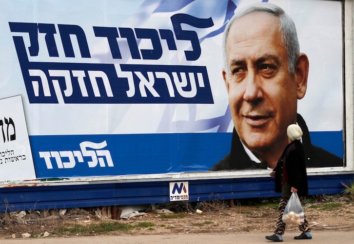 Una mujer árabe camina ante un cartel electoral de Netanyahu en Haifa. (Ahmad GHARABLDI)