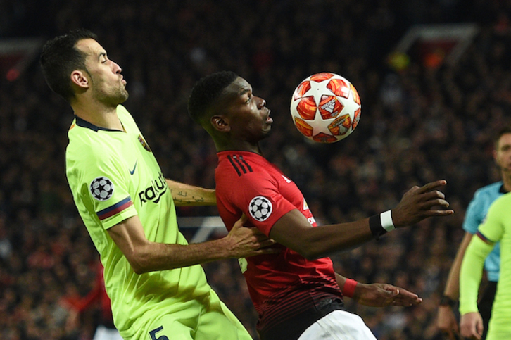 Busquets y Pogba miran el balón en Old Trafford. (Oli SCARFF / AFP)