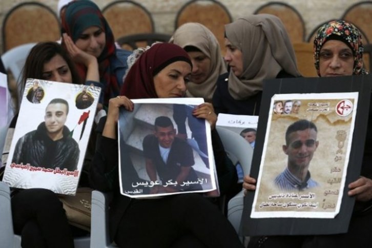 Mujeres palestinas sostiene retratos de sus familiares presos durante una huelga de hambre anterior. (AFP)
