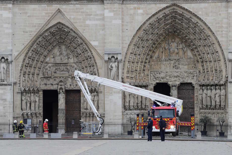 Los bomberos, ante la entrada principal de la catedral. (Thomas SAMSON / AFP) Los bomberos, ante la entrada principal de la catedral. (Thomas SAMSON / AFP)