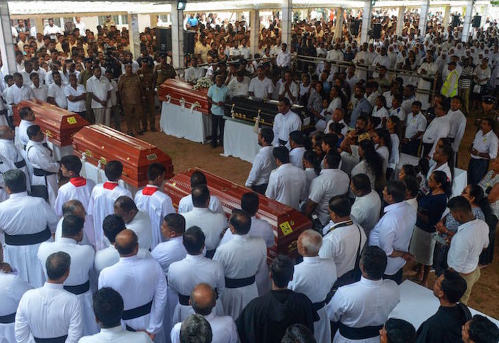 Files y familiares junto a los ataúdes con los cadáveres de algunos de los fallecidos. (Ishara S. KODIKARA/AFP)