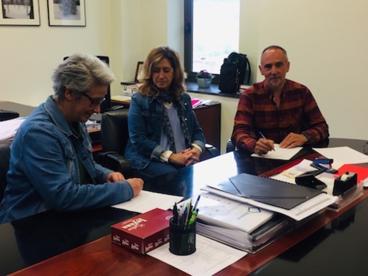 A la izquierda, firmando, Amelia Gurucharri junto a Fuensanta Onrubia, ambas profesoras de la ENT y el director general, Roberto Perez Elorza. (GOBIERNO DE NAFARROA)