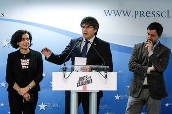 Erika Casajoana, Carles Puigdemont y Toni Comins, en la presentación de la candidatura en Bruselas. (Aris OIKONOMOU / AFP)