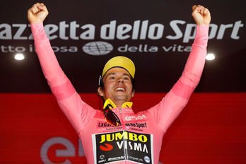 Roglic se muestra feliz al vestirse con la «maglia rosa».(Luk BENIES/AFP)