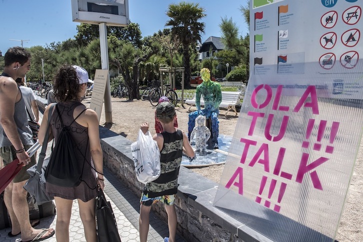Visitantes observan una performance junto al cartel de Olatu Talka. (Gorka RUBIO | FOKU)