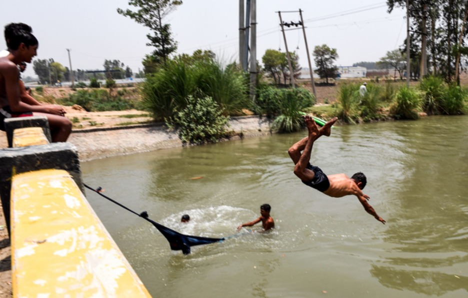 Jovenes se refrescan en el río. (Money SHARMA / AFP)