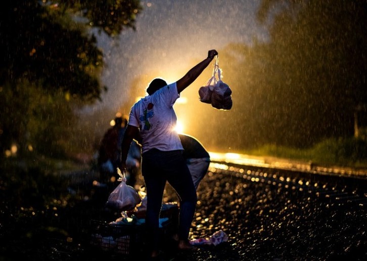 Las patronas obsequian comida en bolsas a los inmigrantes centroamericanos que viajan en La Bestia camino a Estados Unidos. (Foto: Ronaldo SCHEMIDT|AFP)