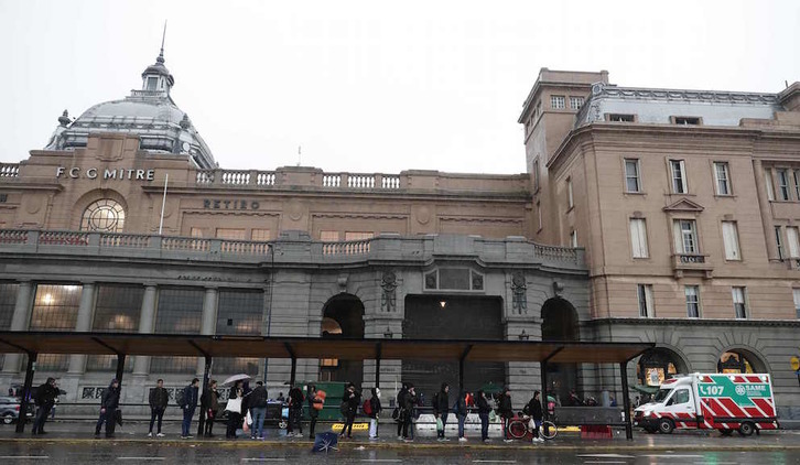 La gente aguarda en una para de autobús en la estación de tren de Retiro, en Buenos Aires, clausurada por el apagón. (Alejandro PAGNI/AFP)