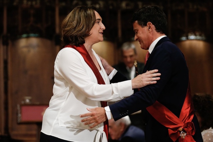 Colau recibe el saludo de Valls el sábado, tras retener el cargo gracias al ex primer ministro. (Pau BARRENA | AFP)