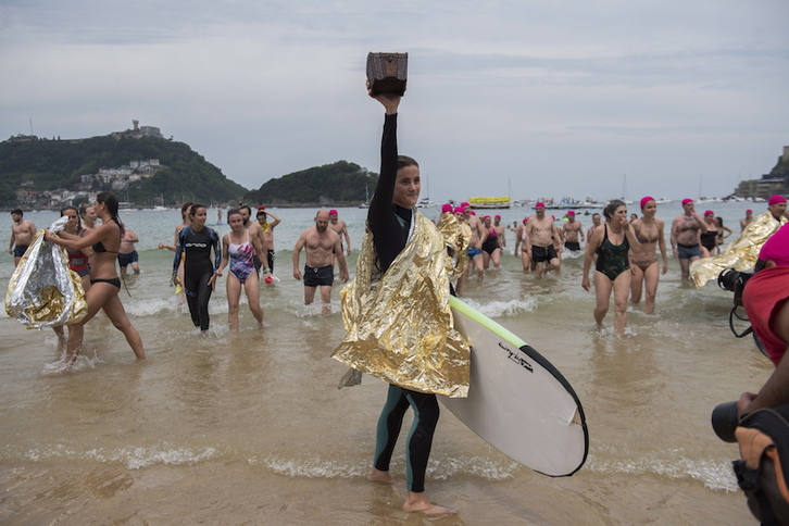 Momento en el que la donostiarra Paula Lapoujade llega a la orilla tras resctar el cofre con la Declaración Universal de los Derechos Humanos en su interior. (Juan Carlos RUIZ / FOKU)