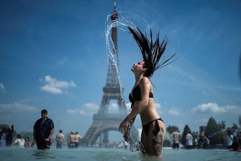 Una joven se baña en la explanada de Trocadero, en París. (KENZO TRIBOUILLARD/ AFP)