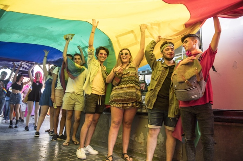 Jóvenes sujetan la bandera del orgullo LGTBIQ+ en Donostia. (Juan Carlos RUIZ/FOKU)