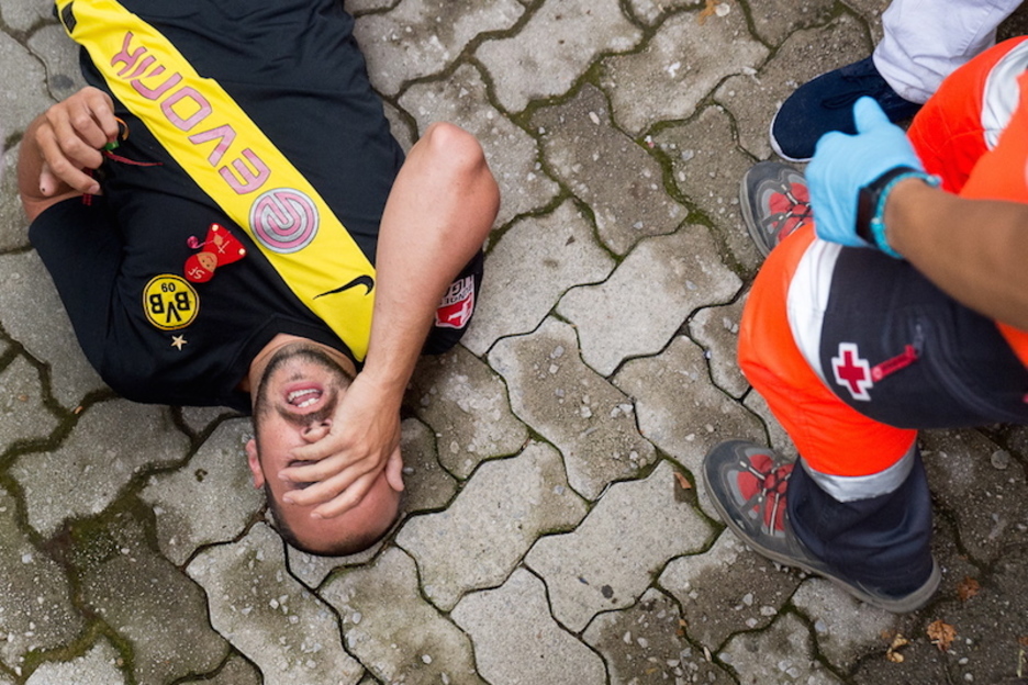 Un corredor con una camiseta del Borussia Dortmund se duele de un traumatismo en el callejón. (Iñigo URIZ | FOKU)