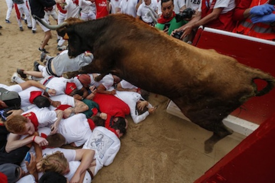 Espectacular salto de una vaca para salvar la barrera de mozos tumbados ante la puerta de corrales. (Iñaki VERGARA/FOKU)