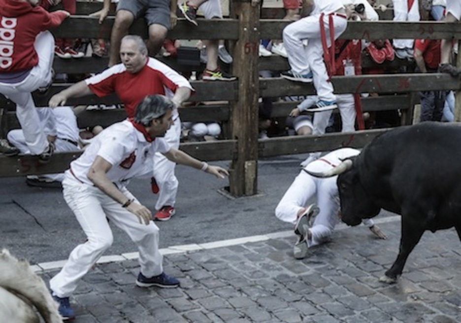 Otro corredor cita al toro para ayudar a su compañero en fuga. (Joseba ZABALZA/FOKU)