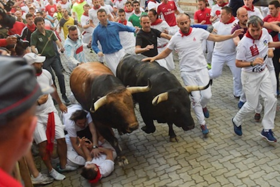  Varios corredores caen al suelo al paso de los bravos por el tramo del callejón. (Idoia ZABALETA/FOKU)