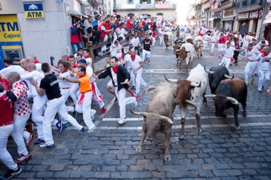 Pregonero, el toro jabonero, consigue adelantarse al manso al tomar la curva de Estafeta. (Iñigo URIZ/FOKU)