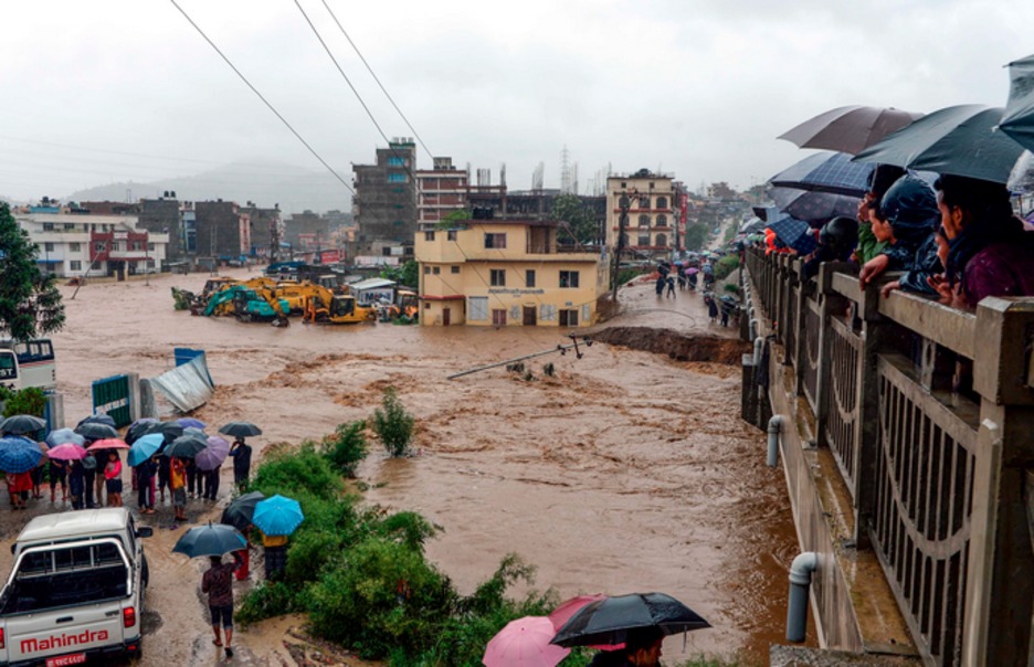 Curiosos observan la riada. (Prakash MATHEMA / AFP)