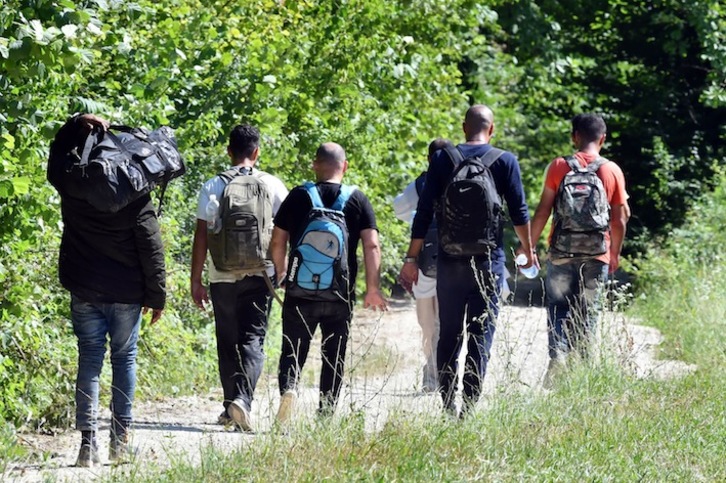 Un grupo de migrantes camina cerca de Bosanska Krupa, en Bosnia. (Elvis BARUKCIC / AFP)