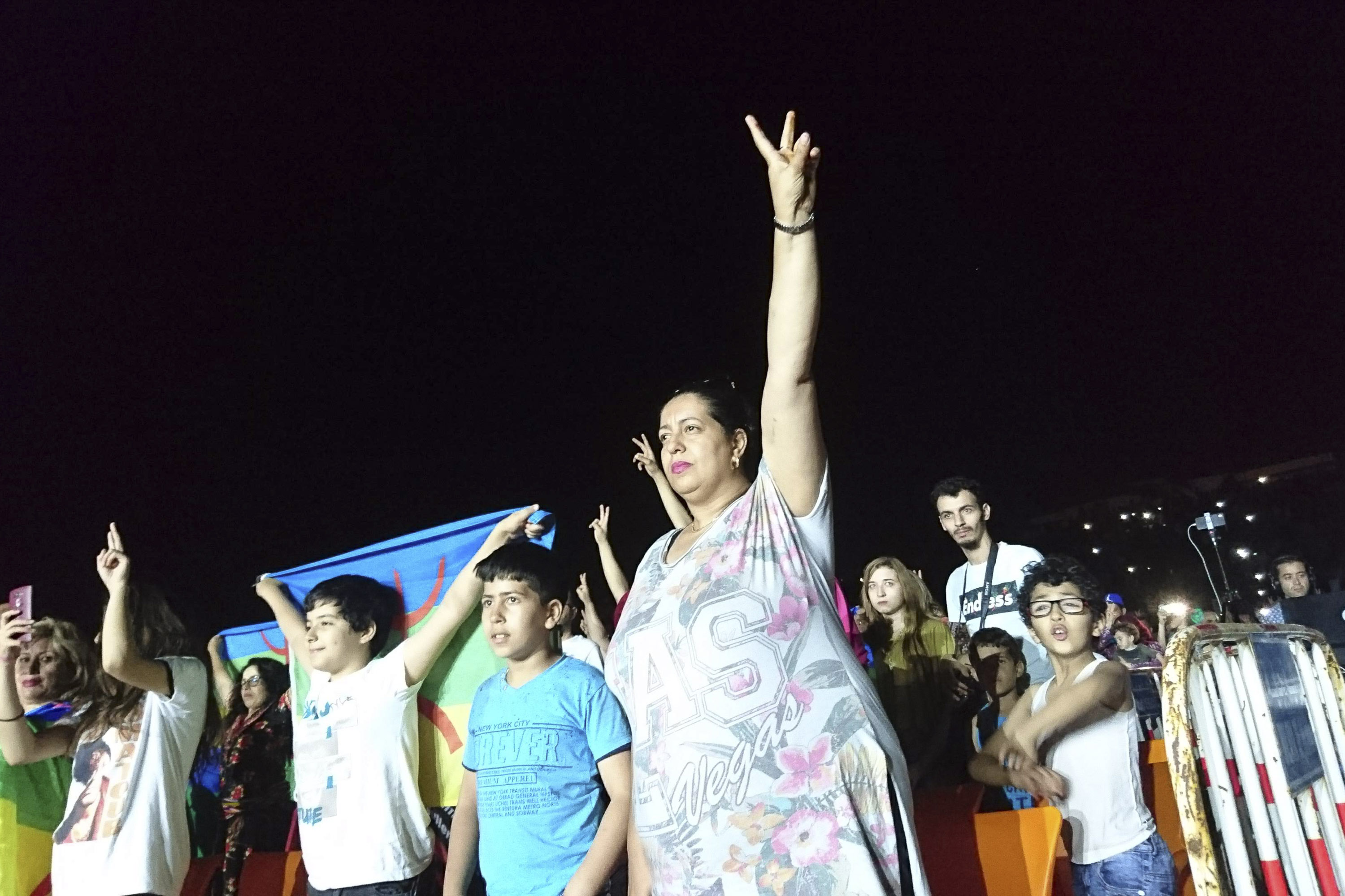 Una mujer hace el signo de la victoria en el estadio donde se celebró el homenaje a Lounes