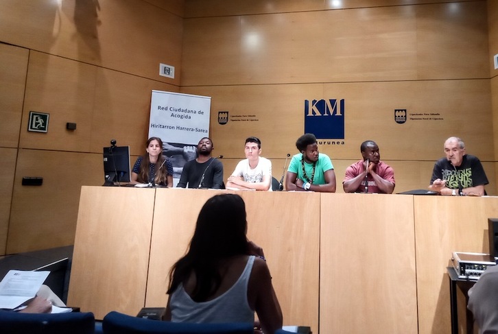 Garazi Garate y Peio Aierbe, en cada esquina de la mesa, y cuatro migrantes han ofrecido la rueda de prensa en el Koldo Mitxelena.